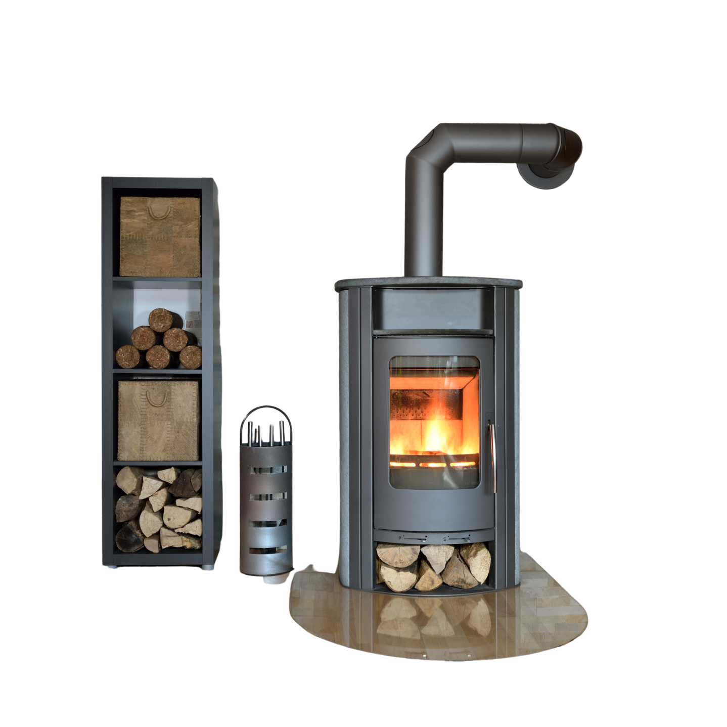 Modern freestanding wood stove with burning fire inside, accompanied by stacked firewood and a metal log holder, all set on a tiled floor against a plain white background.